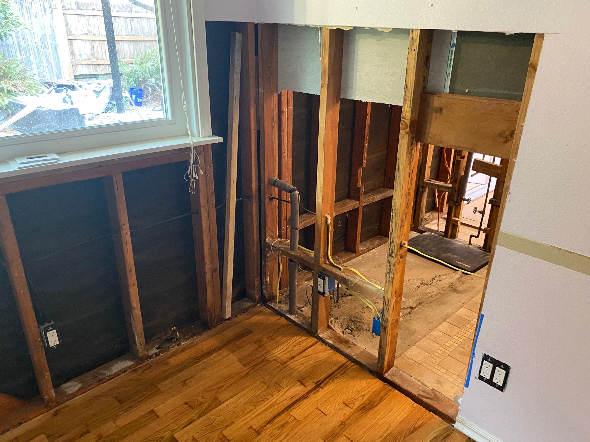 Interior wall opened to studs exposing plumbing and framing during a Prime Environmental Solutions demolition job